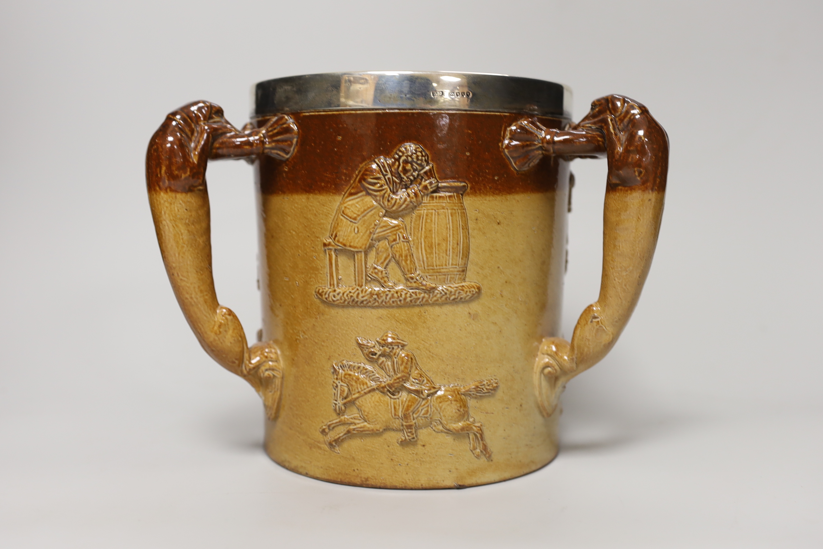 A Doulton Lambeth stoneware three handled tyg with silver collar, hallmarked London 1885, 18cm high